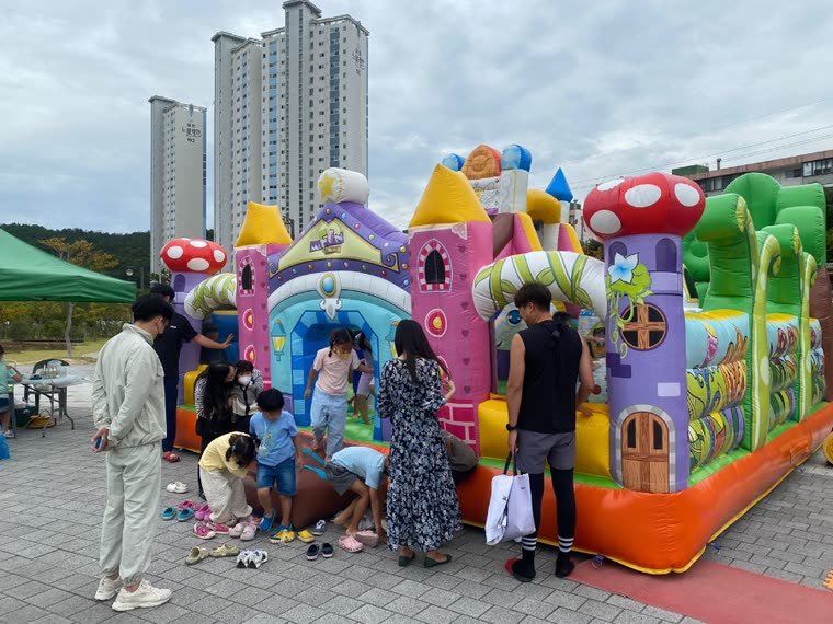 야외 대형 에어바운스 앞에 모인 가족들